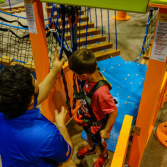 Sky-Tykes-staff-harnessing-boy-participant-RCI-Adventure-Products