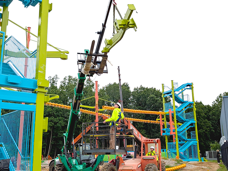 A worker monitors the installation of a section of Sky Rail® at Allegan Event